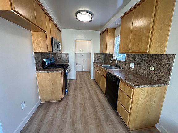Kitchen with new range and new microwave and dishwasher and showing entry to laundry room