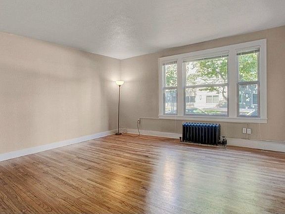Spacious living room with wood floors and large window for natural light!