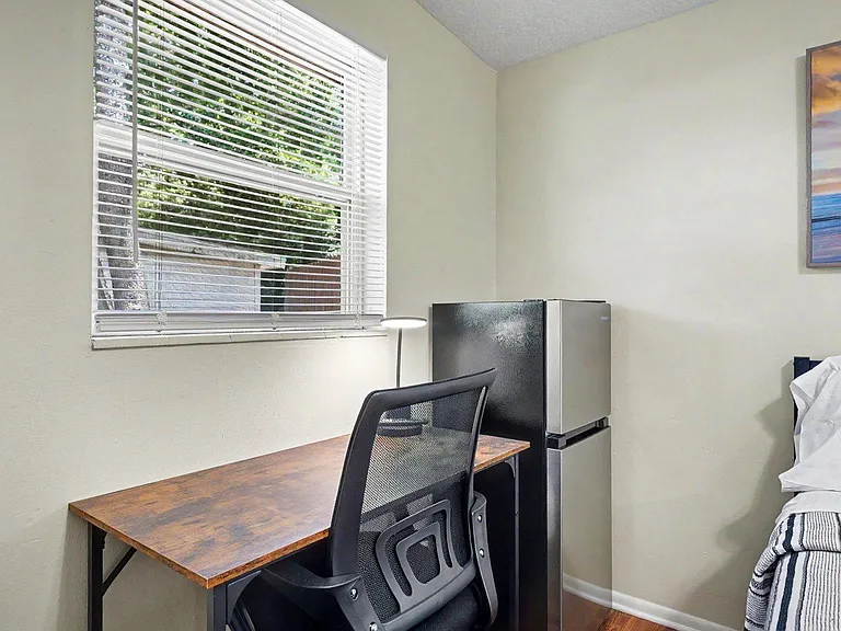 Bedroom setup includes a work desk by the window and an in-room mini fridge w/separate freezer for added convenience.