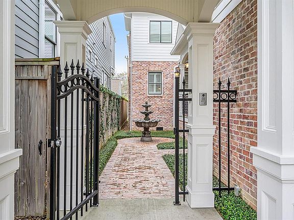 Note the detail of the custom woodwork both outside and inside. Wrought iron fence and gate opens to the courtyard, front door porch and main entry.