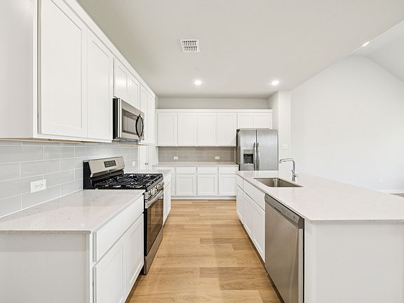 Kitchen in the Masters home plan by Trophy Signature Homes - REPRESENTATIVE PHOTO