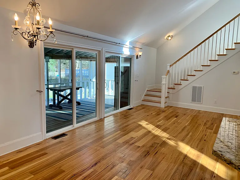 Great room opens by way of two newly installed sliding glass doors to a spacious screened in porch and outdoor patio.