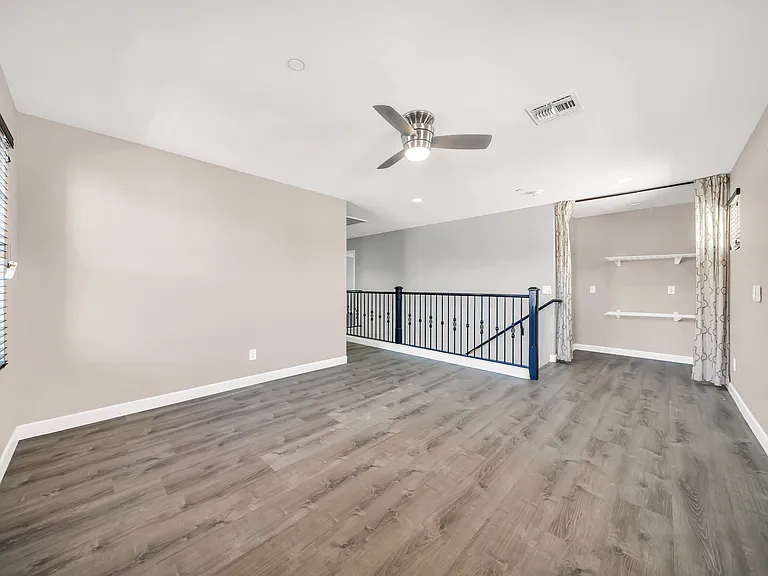 Upstairs loft with built in storage shelving behind curtains