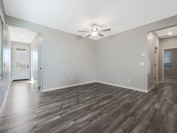 Spacious living room with wood-style flooring and a ceiling fan.