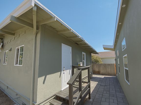 Shared outdoor area. Virtually staged with pavers to highlight improvements under consideration.