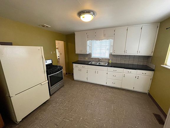 Kitchen with gas stove and granite tile countertops