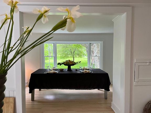 View from the kitchen to an open room with an adjacent bathroom. The current tenant uses this room as a sitting and work room. The space is full of natural light. You have sylvan view of the grounds and a close-up of amazing tree trunk.