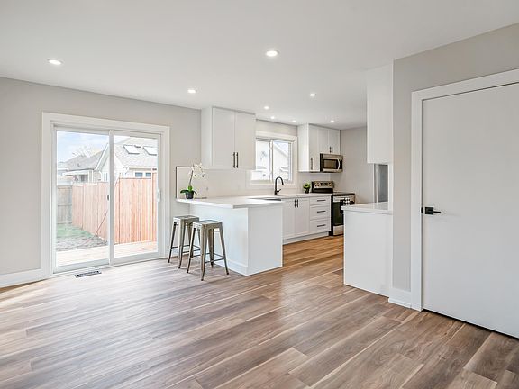 From this perspective you're standing near the living room (front of house) with your back to the front door/living room/foyer. The door on the right is the linen closet with rod and shelving, kitchen is fully renovated with custom cabinets including a co