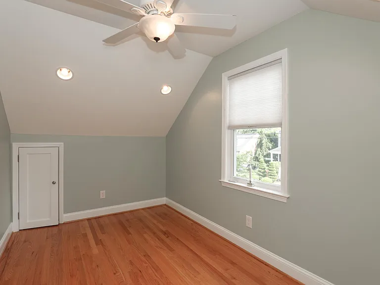 Alternate view of upper bedroom with window and storage access.