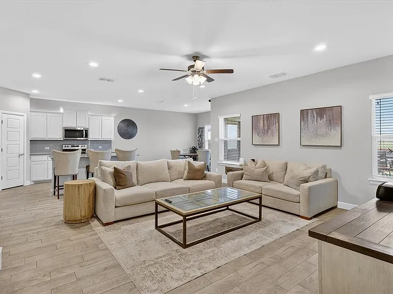 Open-concept living area featuring wood-finish flooring, recessed lighting, and a ceiling fan