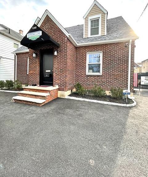 Front of the property, unit 2 entrance on the right side where stairs are located.