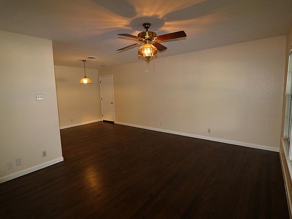 Living and dining area from the front door. Light fixtures have been replaced. Door leads to the garage.