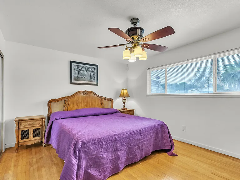 California King sleep number bed with two nightstands, ceiling fan. You have a view of the pool.