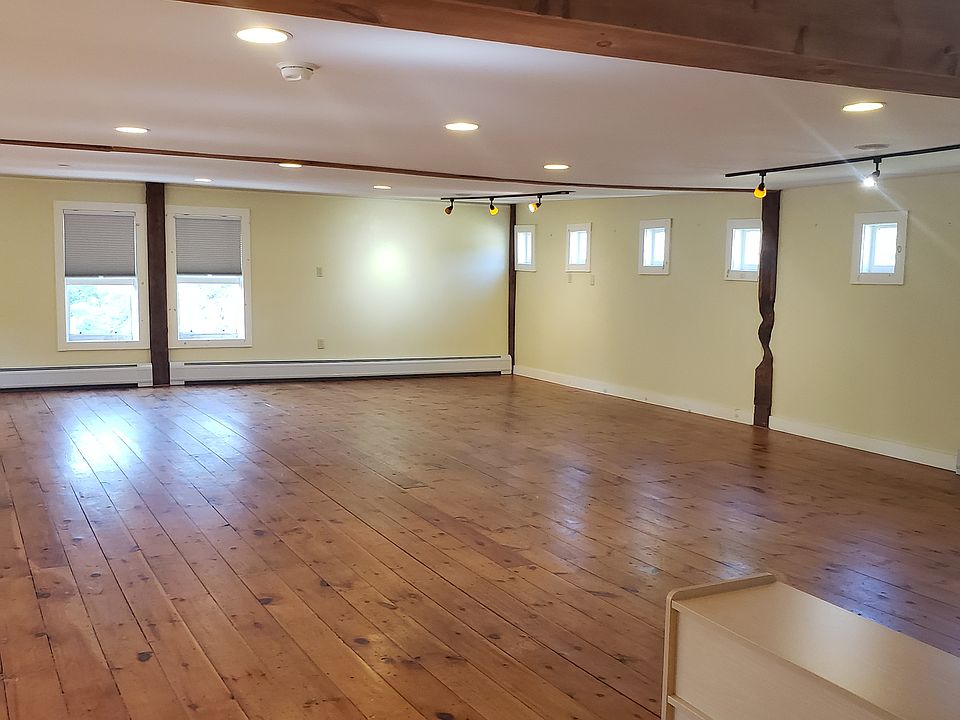Large living area, wide pine floors and exposed beams
