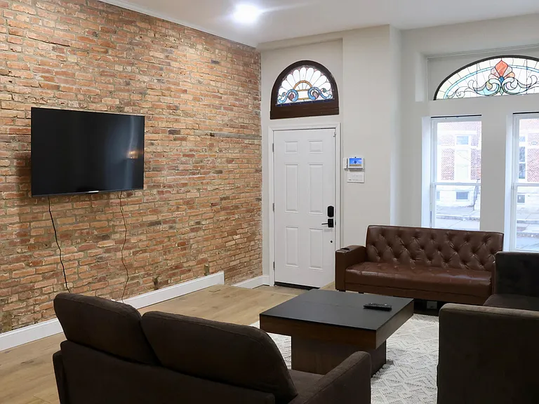 Living room; showcasing the exposed brick and preserved historic Baltimore stained glass transom windows