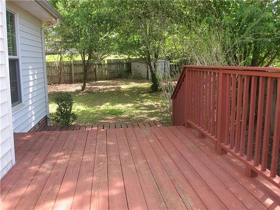 large fenced back yard with deck