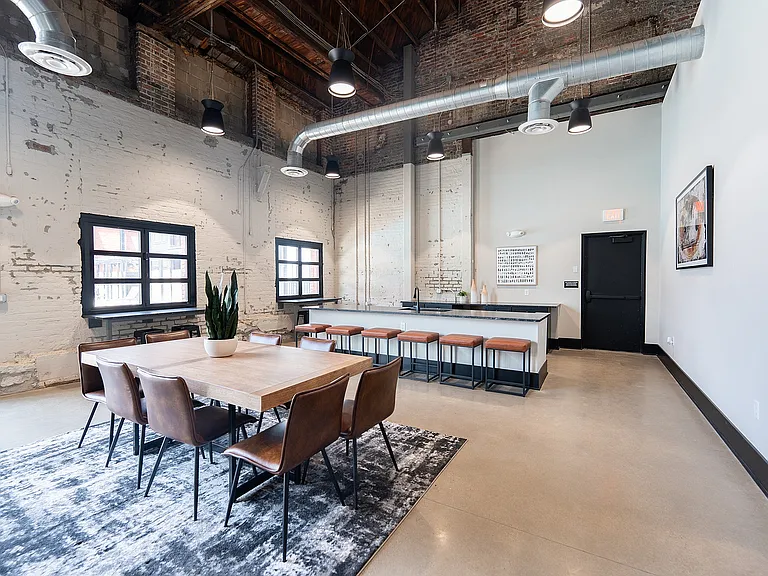 Modern loft-style dining and kitchen area with exposed brick