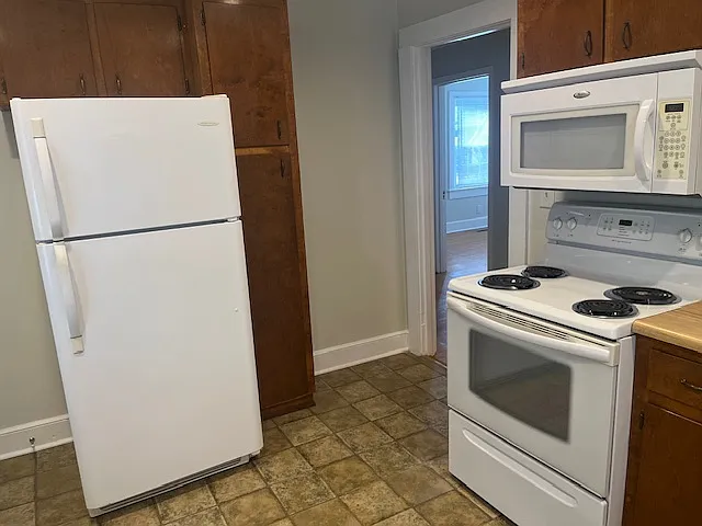 Kitchen with stove and adjacent refrigerator/freezer