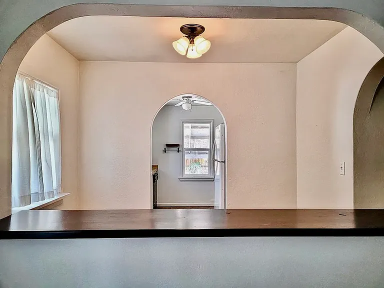 Notice arches into the dining space as well as into the kitchen. Charming light fixture blends with the time period.