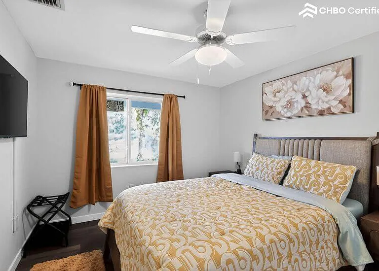 Comfortable guest bedroom with queen bed and TV