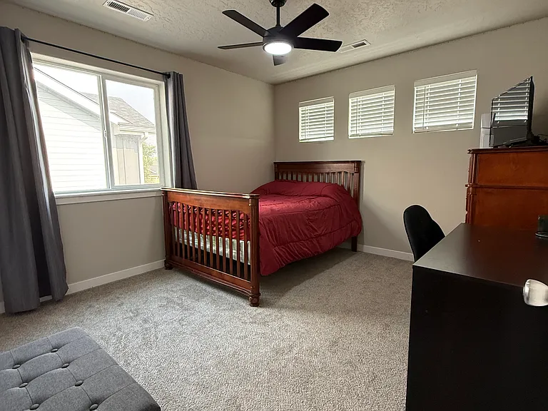 Bedroom with ceiling fan and windows for natural light. Room size about 10'11"x 12'2".