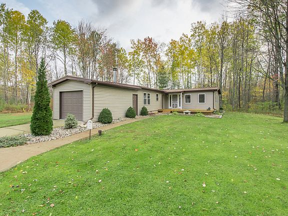 The back view of the home with the newer addition of the attached and heated 1.5 car garage and back deck which leads into the family room at the back of the home.