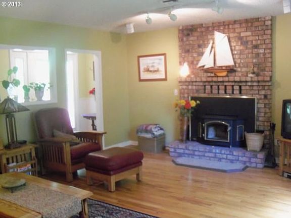 Hardwood floors, large picture windown, and cozy fireplace with a newer woodstove.