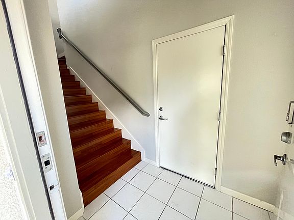 Foyer with stairs leading to the living area. Door leads to the attached garage.