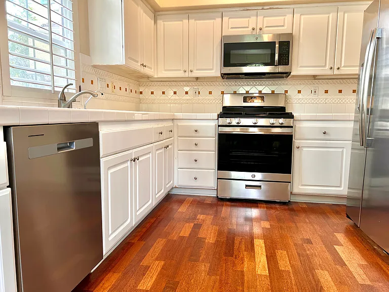 Full stainless steel kitchen with: dishwasher, gas range, microwave, and fridge.