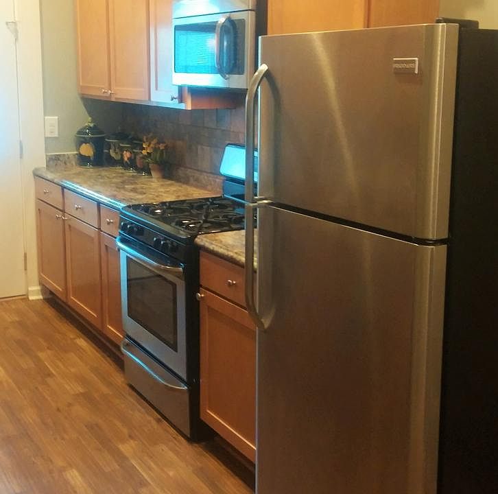 VIEW OF STAINLESS STEEL FRIDGE AND STOVE