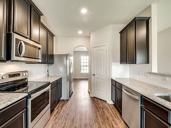 The kitchen showcases granite countertops and stunning wood cabinetry.