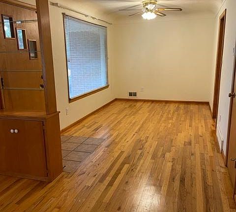 Refinished oak hardwood floors. This is formal dining area with ceiling fan.