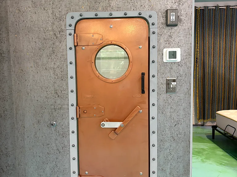 Walk in closet behind authentic ship door.