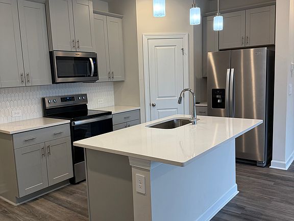 Spacious kitchen plus island seating and pendant lights walk-in Pantry