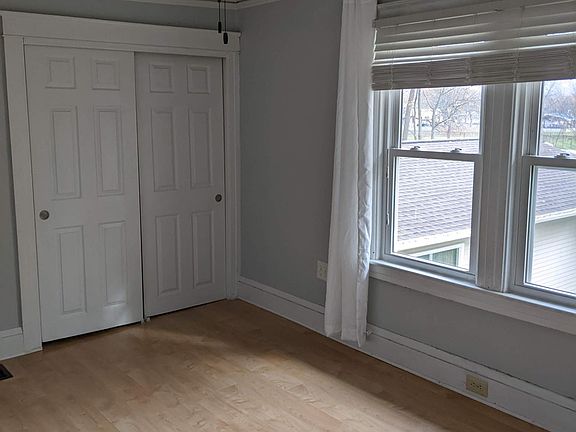 Livingroom with laminate flooring, ceiling fan, 2 windows with blinds for natural lighting, large double closet. Wall color light grey.