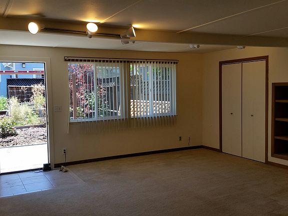 Main room with tiled threshold, closet & shelves, large windows onto garden