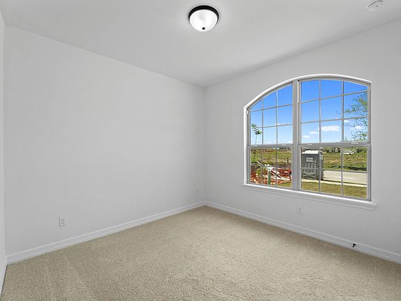 The second bedroom features plush carpet, fresh paint, closet, and a large window that lets in plent