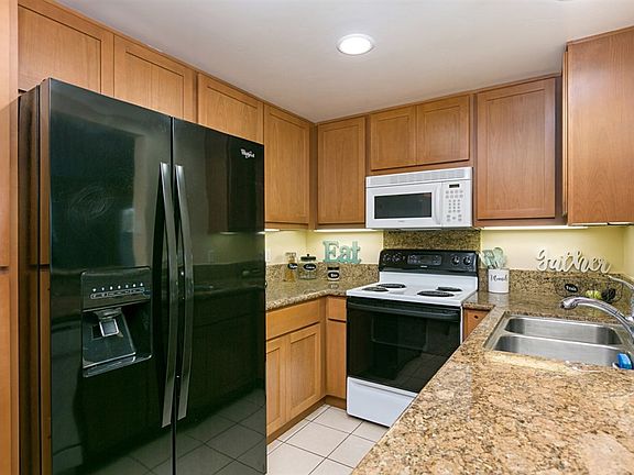 The kitchen boasts beautiful granite counters, maple cabinets, and dual stainless steel sinks.