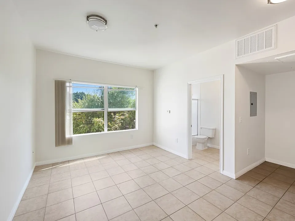 Burlington a bedroom with a large window and a tiled floor