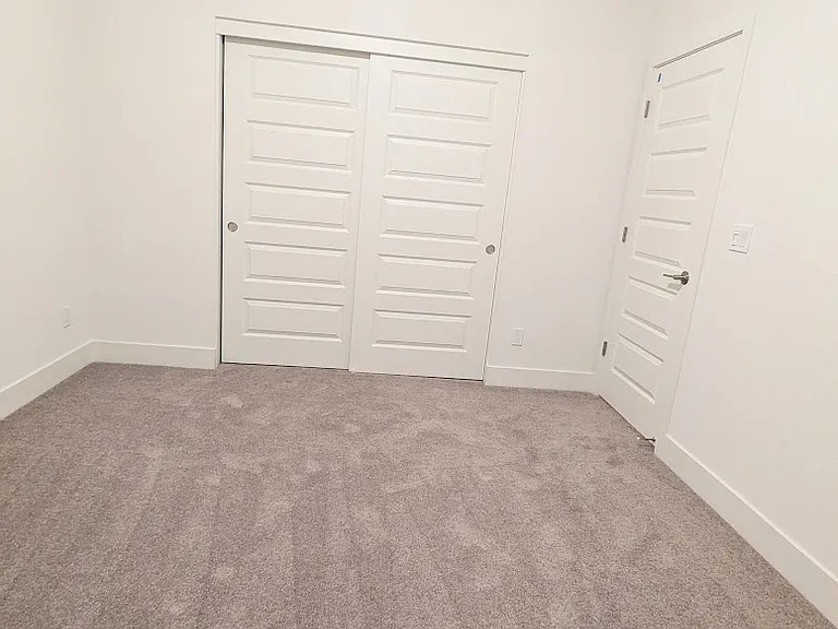 Modern, spacious bedroom featuring a large, generous floor-to-ceiling capacity closet. Easily fits a Queen-size bed with extra room for additional furniture or a workspace. A stylish, bright retreat designed for your comfort and convenience.