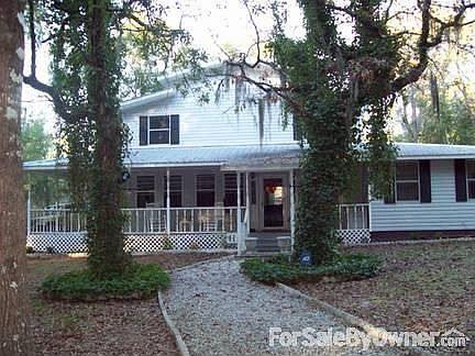 The front of the house with ivy beds on each side of the gravel walkway.