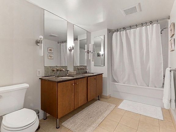 Refresh and recharge in this spa-like bathroom featuring a double vanity, granite countertops, and a full soaking tub for ultimate relaxation.