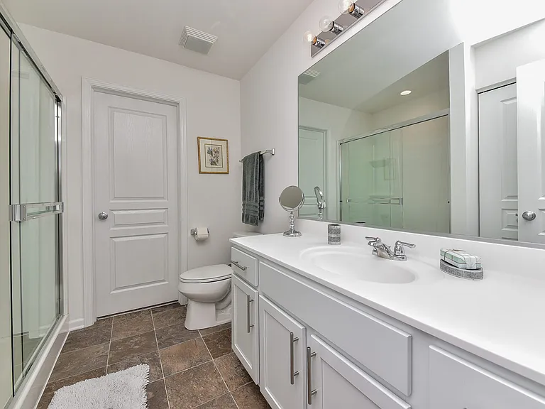 Primary bedroom with attached en suite bathroom and walk in closet