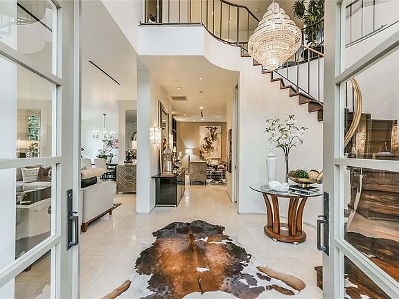 The elegant main entry into the home features incredible curved staircase and looks through the foyer and into the family room.