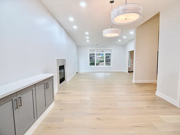 Reverse view of the dining and living area, oriented toward the front entry, showcasing it's open flow and view.