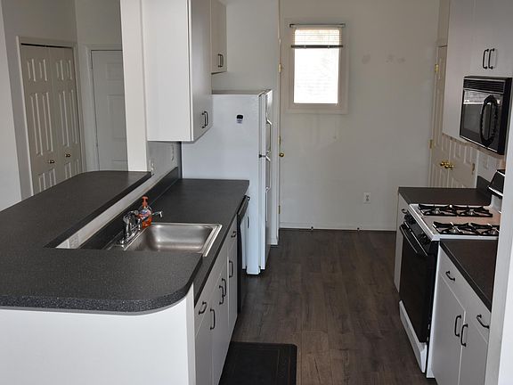 Galley kitchen with fridge, gas over/stove, dishwasher, disposal and plenty of cabinet space