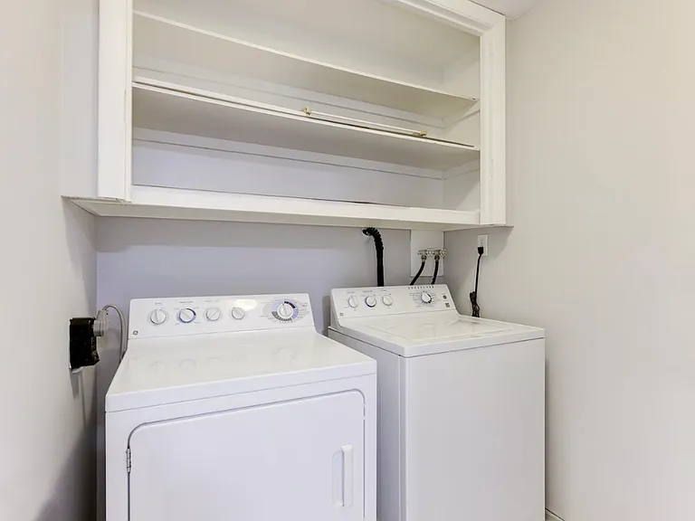 The laundry room is thoughtfully designed with a handy utility sink for easy cleaning and pre-treating stains, plus ample storage cabinets and shelving to keep detergents, cleaning supplies, and linens organized.