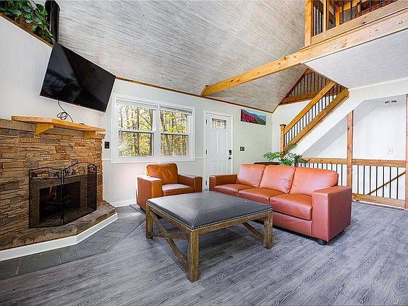 Stone hearth and oak mantel warm the great room's exposed beams and shiplap ceiling. Gather with friends and family.