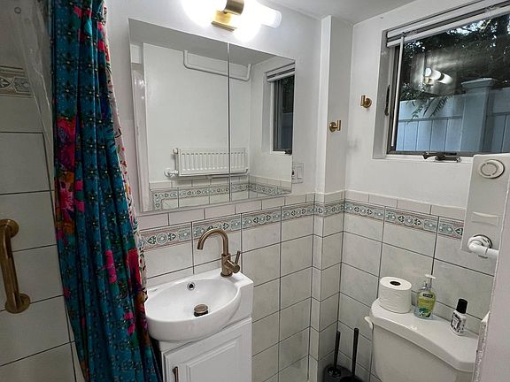 Bathroom with tiled shower new sink
Toilet
tiled floor