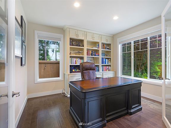 Located just off the front entry glass double doors lead you into the home office with custom built-in cabinets.